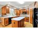 Kitchen featuring wood cabinets, hardwood floors, an island, and modern appliances at 6640 Greenridge Dr, Indianapolis, IN 46278
