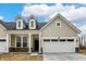 Inviting home with a two-car garage, dormer windows, and brick accent, offering both curb appeal and practicality at 18415 Depoe Ln, Westfield, IN 46074