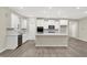 This kitchen features an island, stainless-steel appliances, white cabinets, and hardwood floors at 18415 Depoe Ln, Westfield, IN 46074