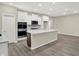 This kitchen features an island, stainless-steel appliances, white cabinets, and hardwood floors at 18415 Depoe Ln, Westfield, IN 46074