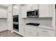 This kitchen features stainless-steel appliances, white cabinets, white countertops, and tile backsplash at 18415 Depoe Ln, Westfield, IN 46074