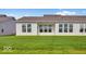 A serene backyard with lush green lawn and the home's exterior showing multiple windows offering plenty of light at 251 Hunters Ridge Dr, Danville, IN 46122