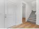Bright foyer featuring a white front door, luxury vinyl floors, and a carpeted staircase at 251 Hunters Ridge Dr, Danville, IN 46122