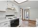 The kitchen features a range and oven combo, white cabinets and access to a sunroom at 521 Eagle Crest Dr, Brownsburg, IN 46112