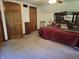 Bedroom with a large bed, carpeted floor, and multiple wood paneled doors for closet space at 6605 Donnelly Dr, Brownsburg, IN 46112