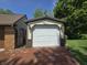 A detached garage with a white door, unique sconce lighting, and brick driveway at 6605 Donnelly Dr, Brownsburg, IN 46112