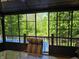 View from screened-in porch overlooking the backyard pool and green trees at 6605 Donnelly Dr, Brownsburg, IN 46112