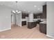 Bright and airy kitchen with dark cabinetry, stainless steel appliances, large island, and modern lighting fixtures at 4186 Dutton Dr, Bargersville, IN 46106