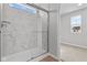 Modern shower with marble-look tile and glass doors, leading to bedroom at 4186 Dutton Dr, Bargersville, IN 46106