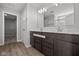 Bathroom with dual sinks, dark wood cabinets, and a door leading to a walk-in closet at 4193 Bozeman Way, Bargersville, IN 46106