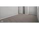 A carpeted room with neutral walls and baseboards with multiple entryways and a window at 4193 Bozeman Way, Bargersville, IN 46106