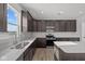 Modern kitchen featuring dark wood cabinets, stainless steel appliances, and quartz countertops at 4193 Bozeman Way, Bargersville, IN 46106