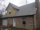 A side view of the brick home features an attached garage, and access door at 2021 N Graham Ave, Indianapolis, IN 46218