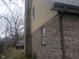 Brick home with yellow siding accents and a view of chimney and adjacent lot at 2021 N Graham Ave, Indianapolis, IN 46218