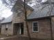 Traditional brick home featuring a symmetrical design, a covered front porch, and mature trees in yard at 2021 N Graham Ave, Indianapolis, IN 46218