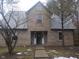 Traditional brick home featuring a symmetrical design, a covered front porch, and a well-maintained lawn at 2021 N Graham Ave, Indianapolis, IN 46218