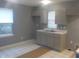 A bright kitchen features neutral colored cabinets, sink, and a window at 2021 N Graham Ave, Indianapolis, IN 46218