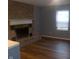 Living room with a brick fireplace, hardwood floors and neutral walls at 2021 N Graham Ave, Indianapolis, IN 46218