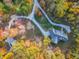 An aerial view of a secluded home with a long driveway, lush landscaping, and surrounded by vibrant fall foliage at 7258 N Richardson Dr, Morgantown, IN 46160