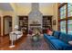 Bright living room with a stone fireplace flanked by bookcases, comfortable seating and wood floors at 7258 N Richardson Dr, Morgantown, IN 46160