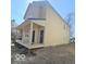 Back of a two-story home featuring a covered porch, neutral siding, and outdoor access at 2018 Rembrandt St, Indianapolis, IN 46202
