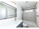 Modern bathroom with gray tile, white vanity, and bathtub at 4902 N Park Ave, Indianapolis, IN 46205