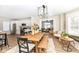 Open concept dining room with a large wooden table, a bench, and views of the living room and kitchen at 4902 N Park Ave, Indianapolis, IN 46205