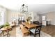 Open dining room with view to sitting area, kitchen, wood floors, and a modern chandelier at 4902 N Park Ave, Indianapolis, IN 46205