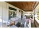 Relaxing front porch with wooden ceiling, seating area, and tiled floor at 4902 N Park Ave, Indianapolis, IN 46205