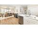 Open kitchen and dining room with white cabinets, quartz counters, stainless appliances, and modern light fixture at 4902 N Park Ave, Indianapolis, IN 46205