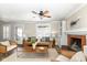 Comfortable living room featuring wood floors, a ceiling fan, and a brick fireplace with built-in shelving at 4902 N Park Ave, Indianapolis, IN 46205