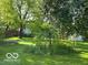 Spacious backyard features mature trees, green grass, and a playground with slide, perfect for outdoor enjoyment at 534 Austrian Way, Avon, IN 46123