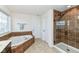 Spa-like bathroom with soaking tub, walk-in shower, and tiled flooring at 6252 Sugar Maple Dr, Zionsville, IN 46077