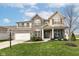Two-story brick home with a welcoming front porch and landscaped lawn at 6252 Sugar Maple Dr, Zionsville, IN 46077
