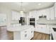 Open kitchen design boasts white cabinets, stainless steel appliances, a central island, and hardwood floors at 794 Princeton Ln, Westfield, IN 46074