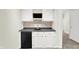 Basement wet bar with white cabinetry, black countertop, mini-fridge and decorative backsplash at 794 Princeton Ln, Westfield, IN 46074