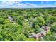An aerial shot shows the home nestled amongst dense trees in a serene neighborhood setting at 2505 Riverside Dr, Columbus, IN 47201