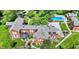 An aerial view shows the expansive brick home with pool, lush landscaping, and circular driveway at 2505 Riverside Dr, Columbus, IN 47201