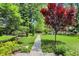 Stone pathway winds through a lush backyard with mature trees and manicured landscaping, creating a serene setting at 2505 Riverside Dr, Columbus, IN 47201