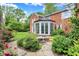 Beautiful backyard with a brick home, garden, fountain, and a charming sunroom addition at 2505 Riverside Dr, Columbus, IN 47201