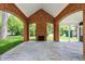 Covered patio with brick arches and a stone floor highlighting an outdoor fireplace overlooking the backyard at 2505 Riverside Dr, Columbus, IN 47201