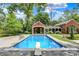 Pool and pool house featuring a diving board, a stone patio, and manicured landscaping at 2505 Riverside Dr, Columbus, IN 47201