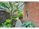 Landscaped side yard featuring mature trees, a stone walkway, and a unique round window at 2505 Riverside Dr, Columbus, IN 47201
