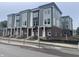 Modern townhomes boast a stylish brick and siding facade, white pillars, and large windows at 2611 E New York St, Indianapolis, IN 46201