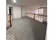 Open loft area with wood railing and plush carpeting at 6362 Harmonridge Ct, Indianapolis, IN 46278