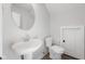 Small bathroom with pedestal sink, toilet and round mirror at 804 James William Ln, Westfield, IN 46074