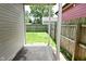 Backyard featuring green grass and wood fence, as viewed from a covered porch at 1709 Hoyt Ave, Indianapolis, IN 46203