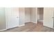 Bedroom with neutral paint, base trim, and wood look floors, plus two doors to adjoining rooms at 1709 Hoyt Ave, Indianapolis, IN 46203