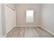 Bedroom featuring wood look floors, neutral paint, a double closet and a window for natural light at 1709 Hoyt Ave, Indianapolis, IN 46203