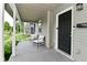 Inviting covered front porch with chairs, a black front door, and a secure keypad at 1709 Hoyt Ave, Indianapolis, IN 46203
